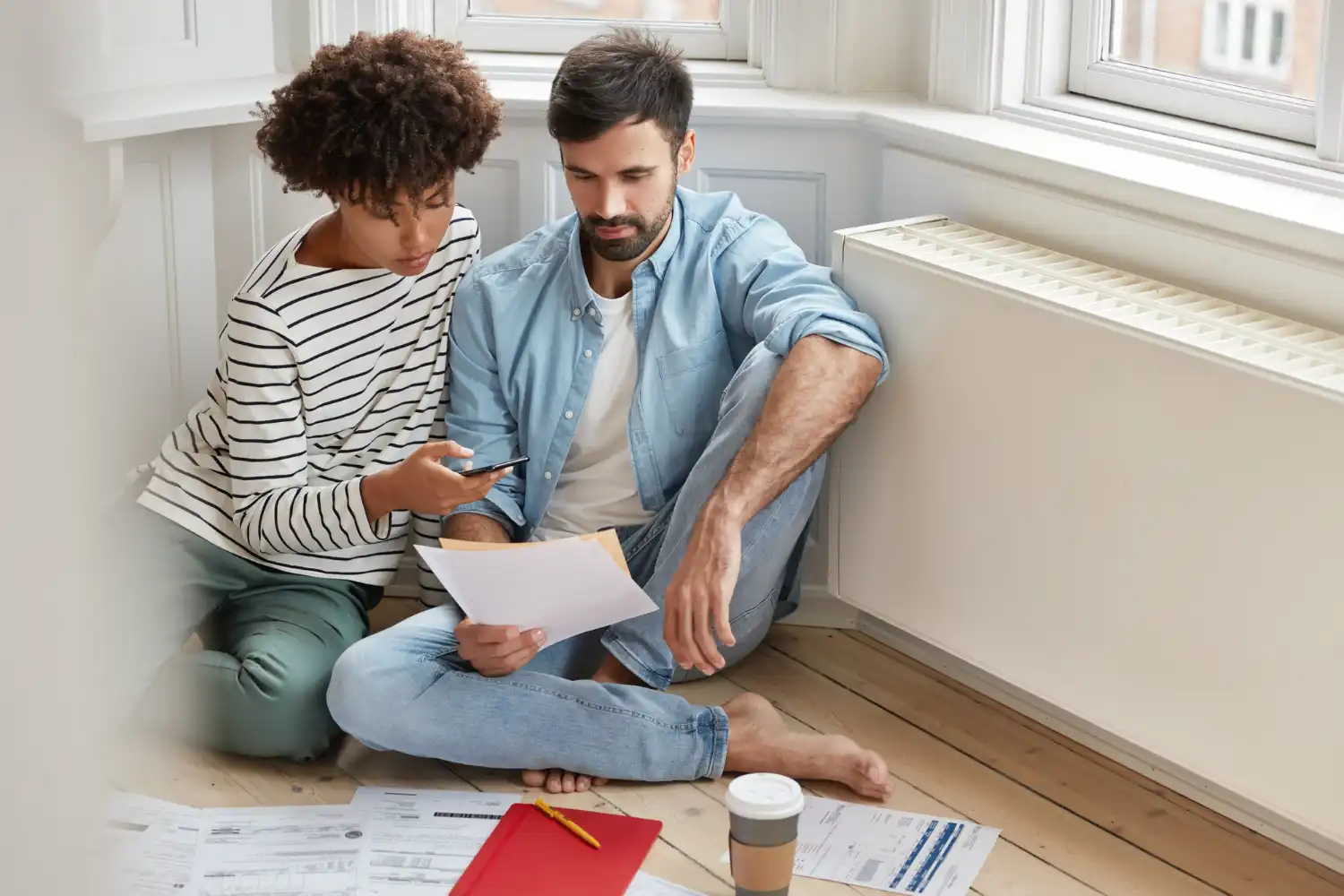 Imagem de um casal discutindo documentos financeiros em casa, destacando a importância de itens essenciais para o primeiro lar, como aquecedor solar, por que investir neste item.