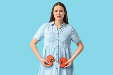 Mulher com expressão preocupada segura ilustrações de rins na região abdominal, sobre fundo azul, representando dor ou problema renal.