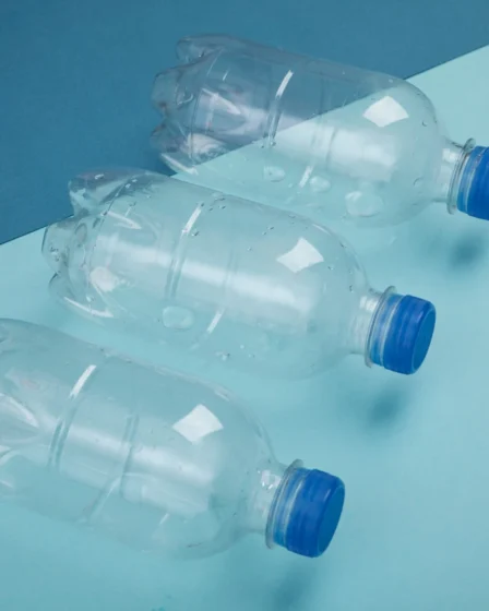 Imagem de três garrafas PET transparentes, destacando sua preferência entre os consumidores, com fundo azul e uma composição que evidencia o uso do produto.